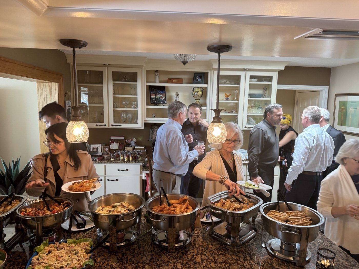 Guests serving themselves from a chafing line at a catered party in Winter Park